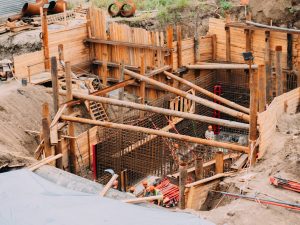 Avaleht Aerial view of a construction site with workers, wooden framework, and scaffolding.