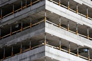 Avaleht Close-up of an unfinished multi-level concrete building with steel reinforcements.