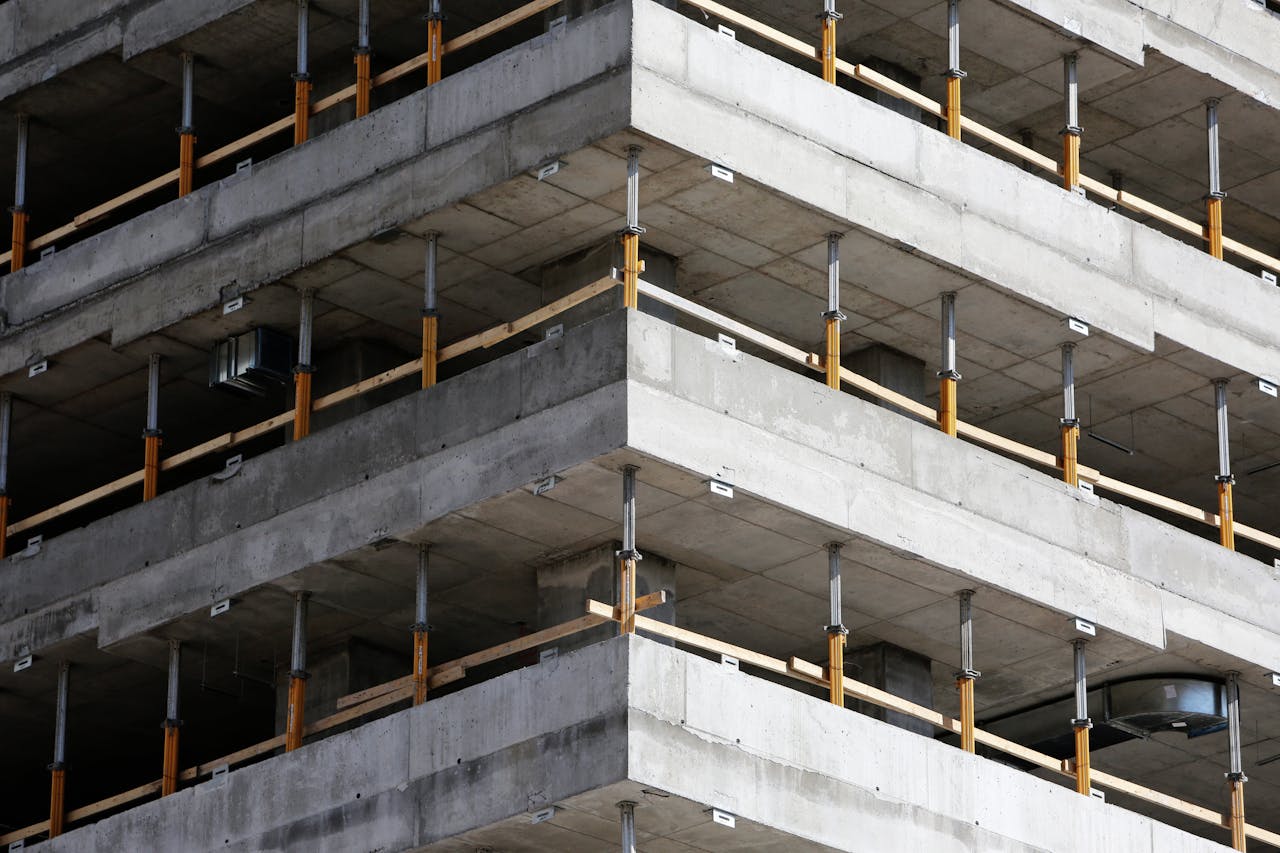 about-us Close-up of an unfinished multi-level concrete building with steel reinforcements.